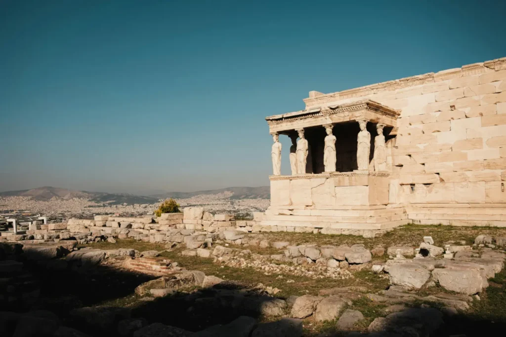 Ancient Greek ruins with statues under a blue sky, representing global cultural exploration on the Artsy Trips blog.