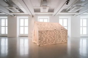 Emily Jacir’s installation The Tent, featuring hand-stitched names of destroyed Palestinian villages, displayed at EMST in Athens, a leading contemporary art museum in Athens.